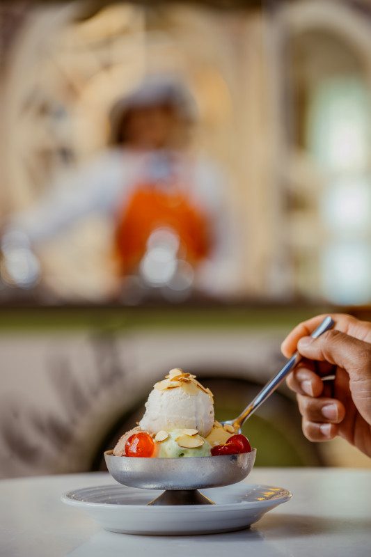 Gelato being scooped and garnished.