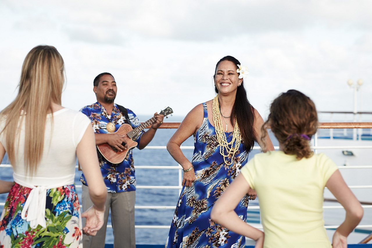 hawaii cruise onboard hula lesson ukulele player guests dancing