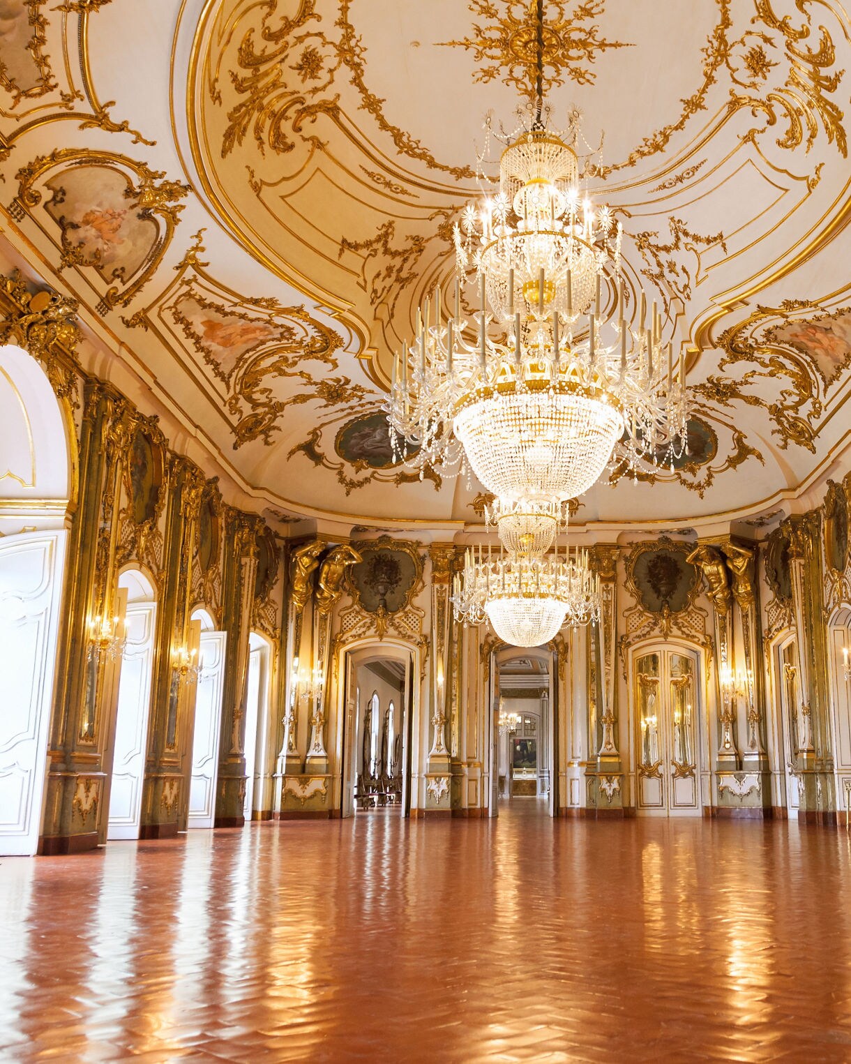 Ornate palace hall with gilded walls, mirrored panels, chandeliers, and painted ceiling details at ʻIolani Palace in Honolulu.