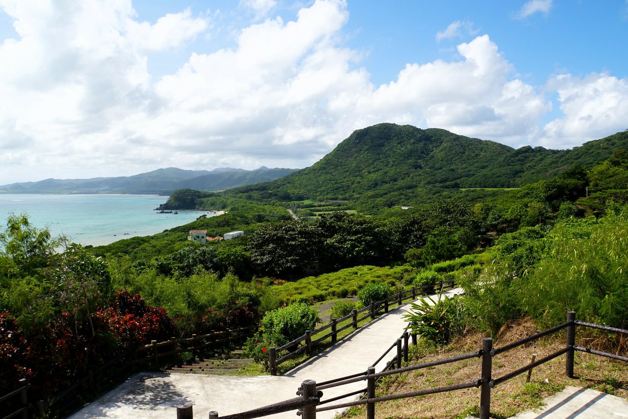 Pathway winds through green hills overlooking blue ocean at Tamatorizaki Observatory.