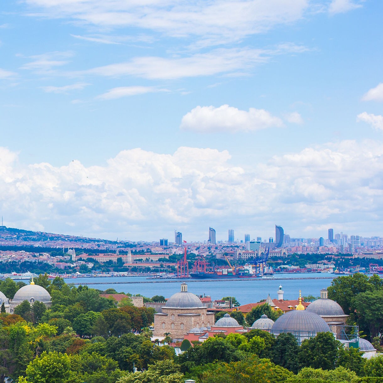 Rooftop view of Istanbul with the Hagia Sophia’s domes and minarets framed by the Bosphorus and city skyline in the distance.