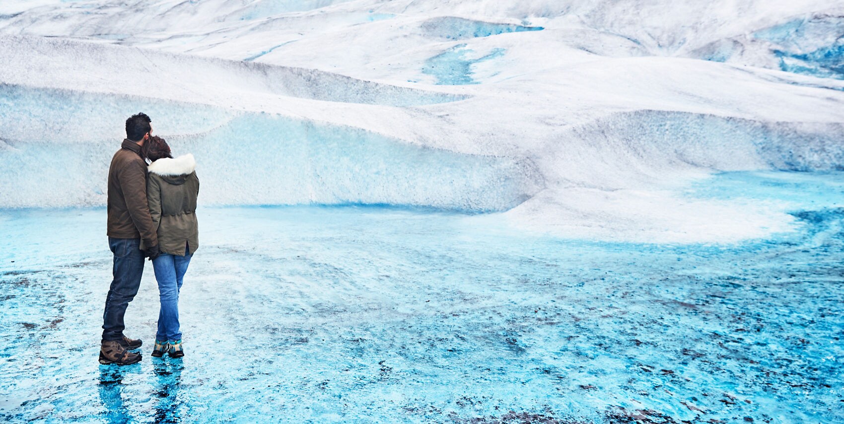 Couple standing together, admiring a glacier