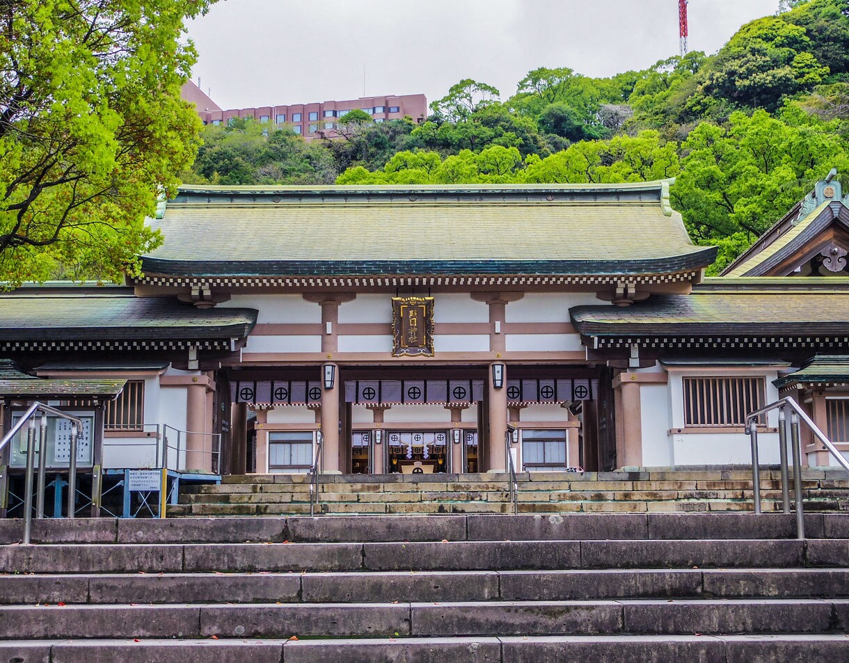 Terukuni Shrine in Kagoshima, Japan, seen from stone steps, with traditional wooden architecture and green trees in the background.
