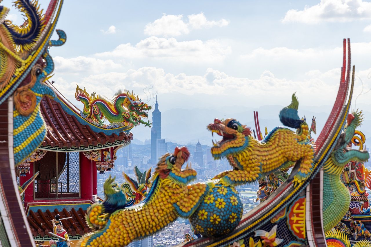 Colorful dragon sculptures decorate the red tiled rooftops of Bishanyan Temple in Keelung