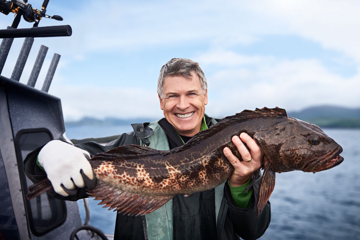 A man showing off a fish he caught in Ketchikan while on an Alaska cruise