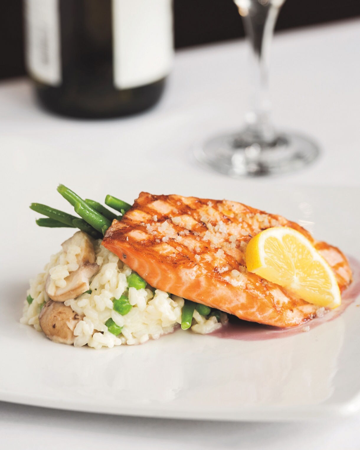 Sea‑salt accented king salmon served over a fresh vegetable risotto.