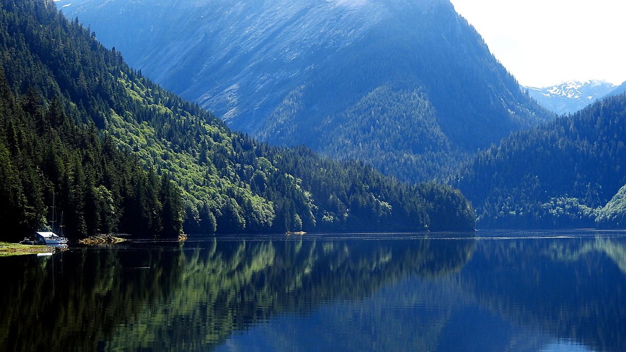A serene lake surrounded by lush green mountains in Prince Rupert. 