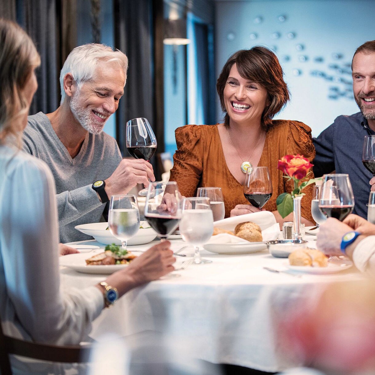 three men and two women dining at a table