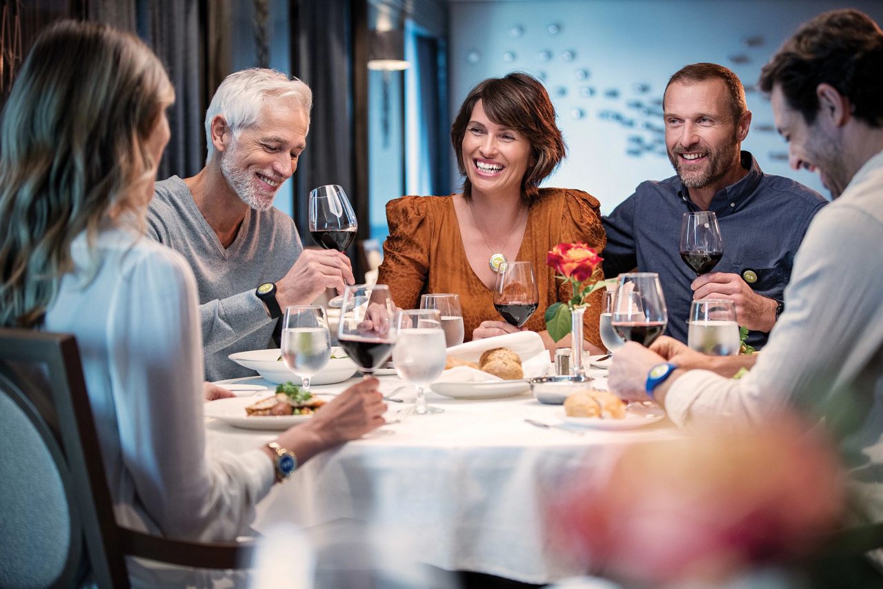 three men and two women dining at a table