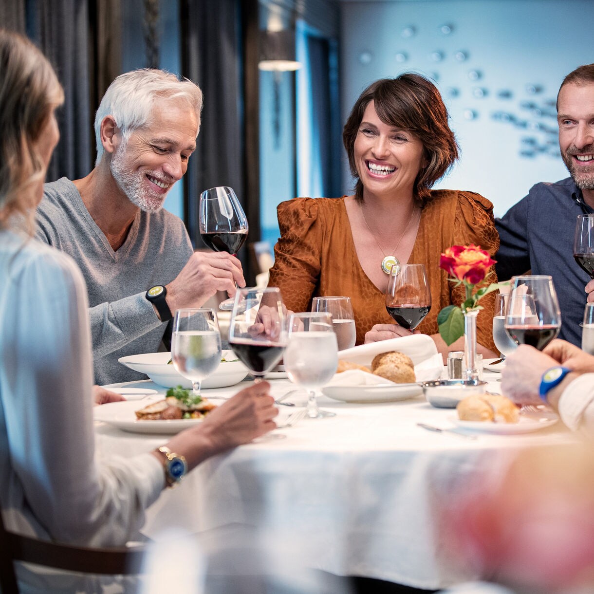 three men and two women dining at a table