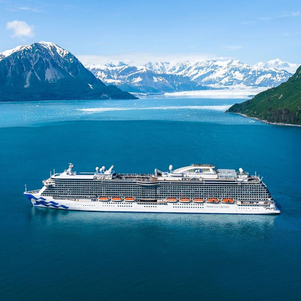 A stunning cruise ship navigates the calm waters, creating a picturesque scene of travel and tranquility under the open sky.