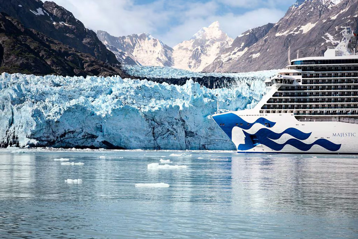 Glacier Bay National Park with a Princess cruise ship sailing in icy waters, surrounded by massive glaciers and snow-capped mountains under a clear sky.