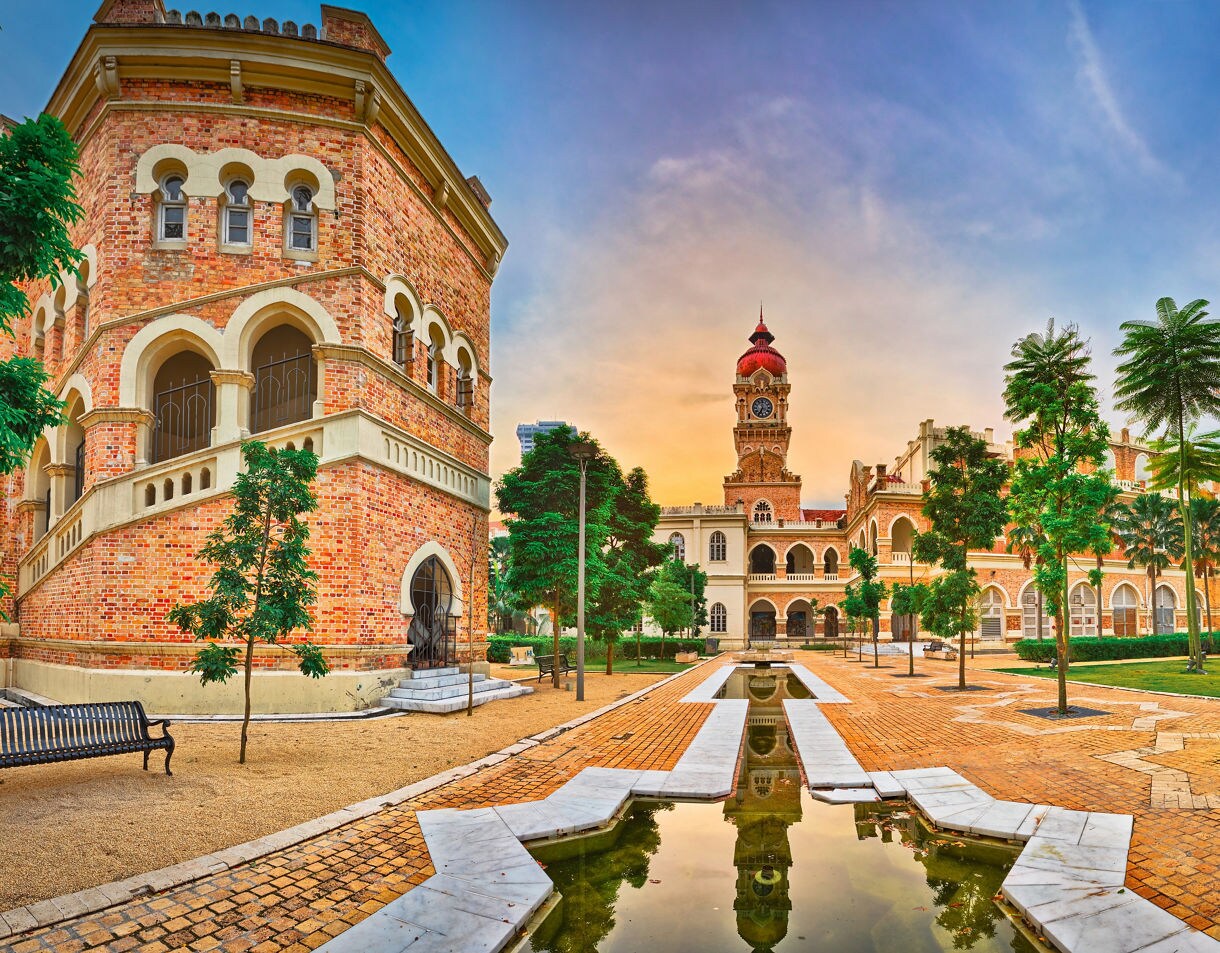 Sultan Abdul Samad Building at Merdeka Square in Kuala Lumpur with red brick arches, clock tower and landscaped gardens.