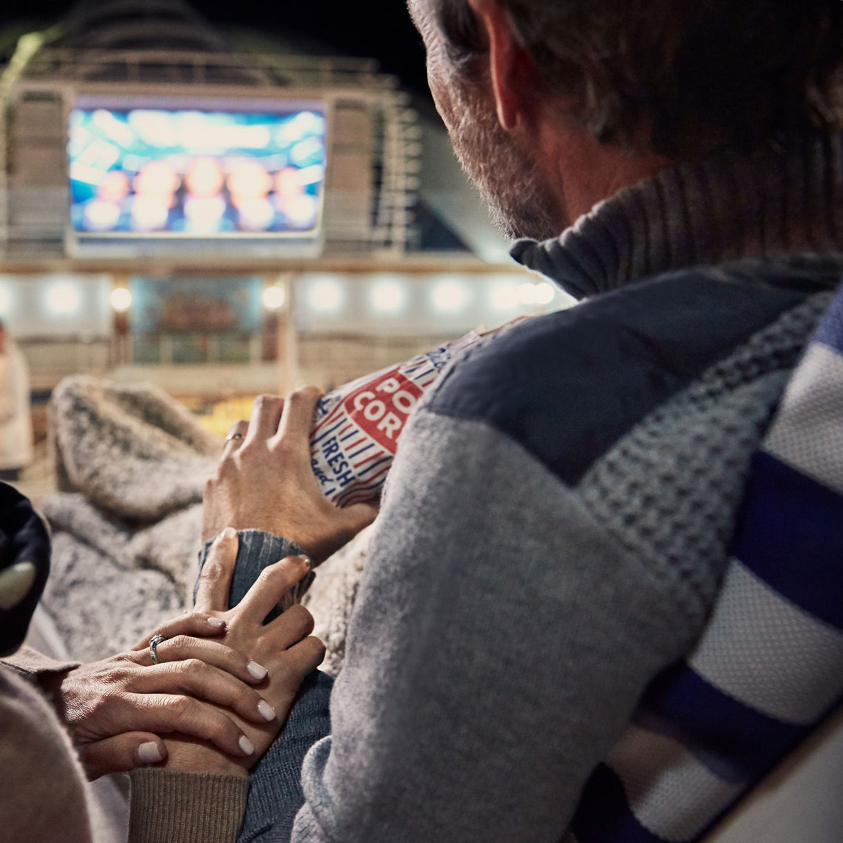movies under the stars couple holding hands