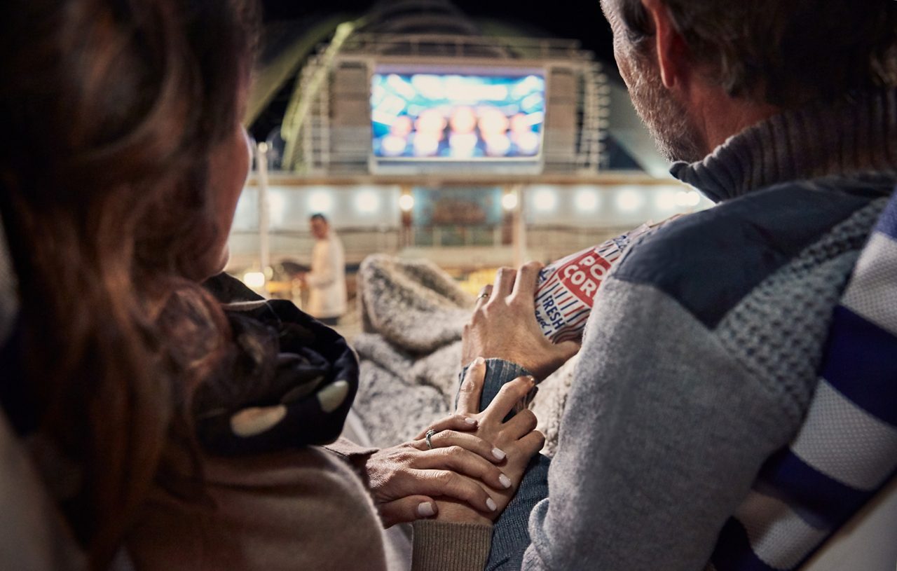 movies under the stars couple holding hands