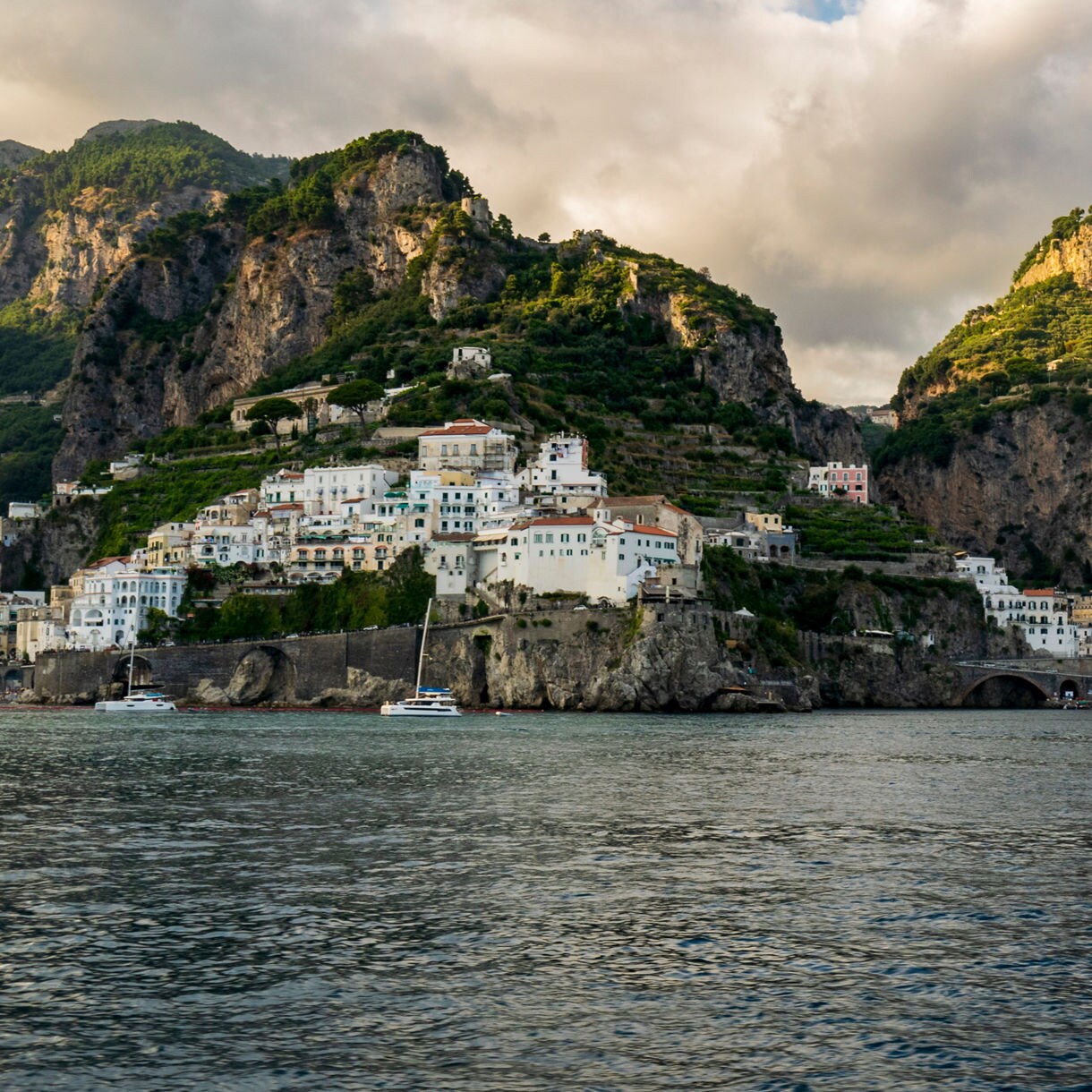 Colorful hillside villages along the Amalfi Coast, framed by steep cliffs and the sea.