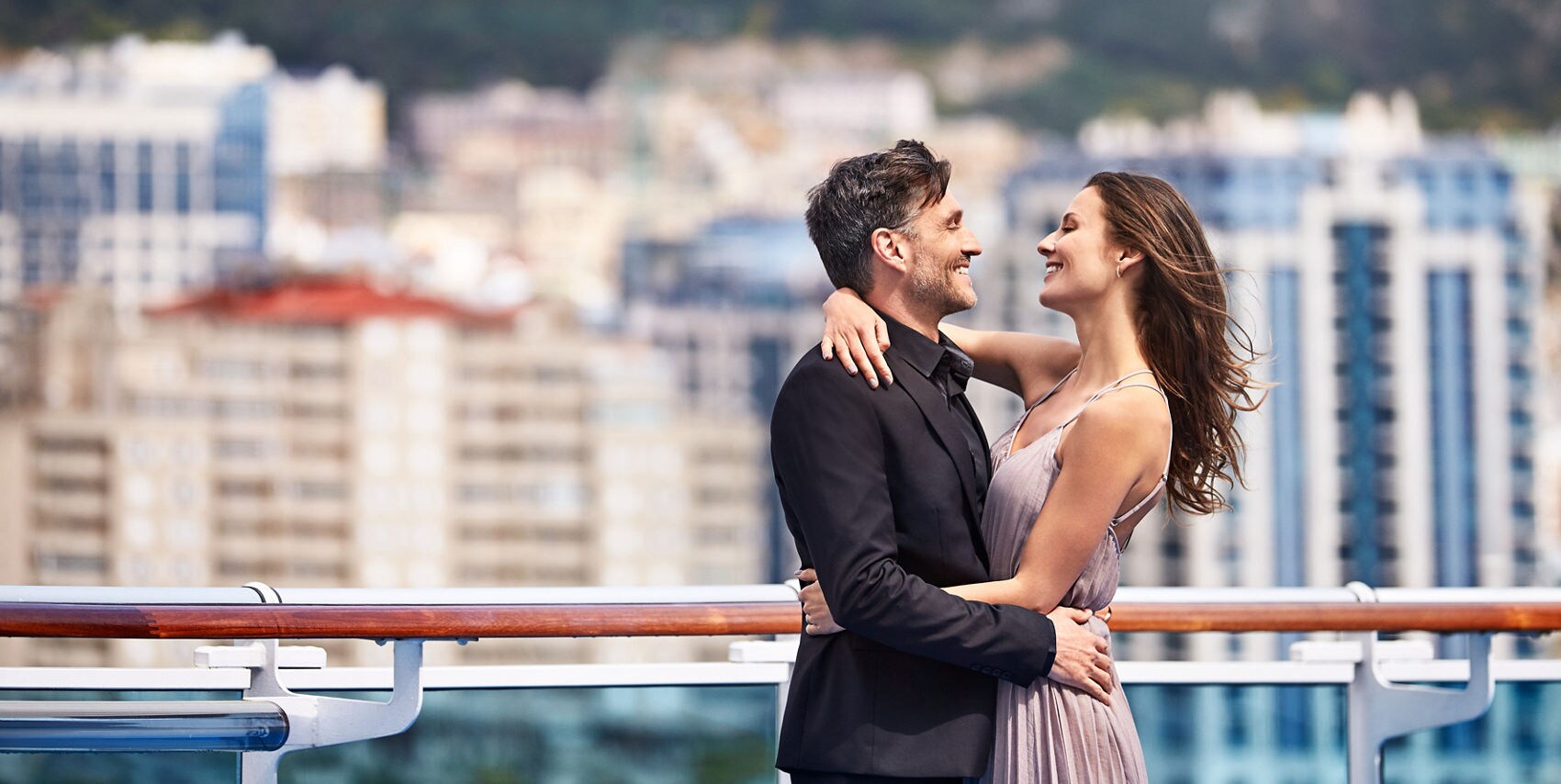 Couple dressed in formal wear, embracing on deck