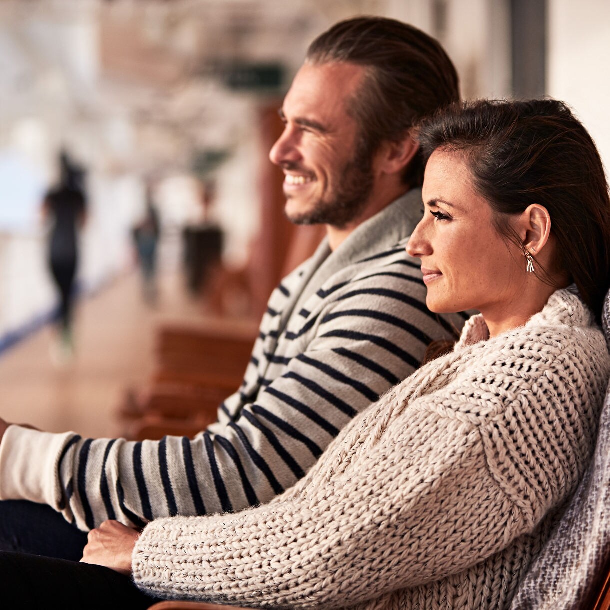 Couple sitting on deck with binoculars sightseeing with peace of mind thanks to EZAir.