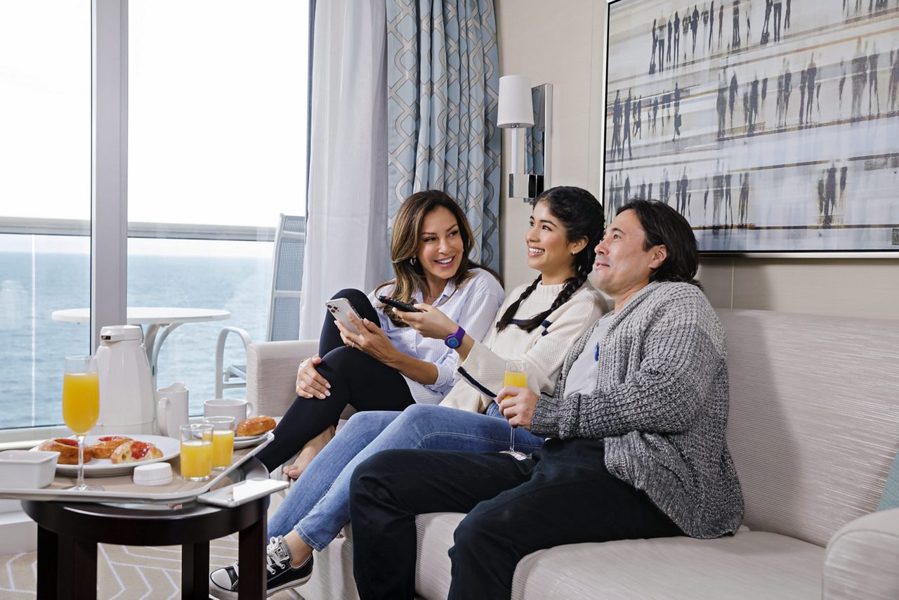 A woman watching OceanView shows in their stateroom.