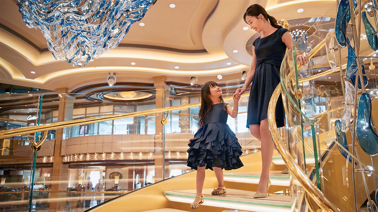 mother and daughter, holdings hands, walking down a staircase