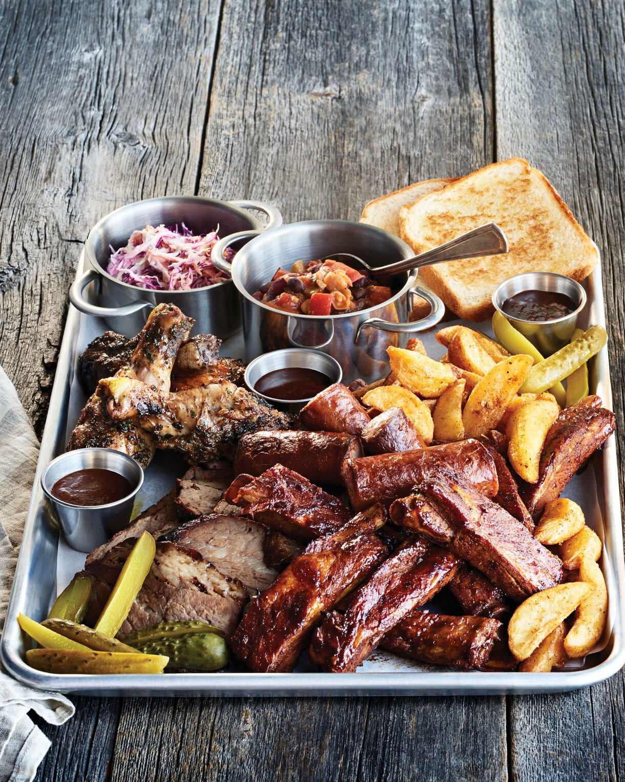 Interior view of Plank's BBQ restaurant featuring rustic decor and BBQ platter presentation.