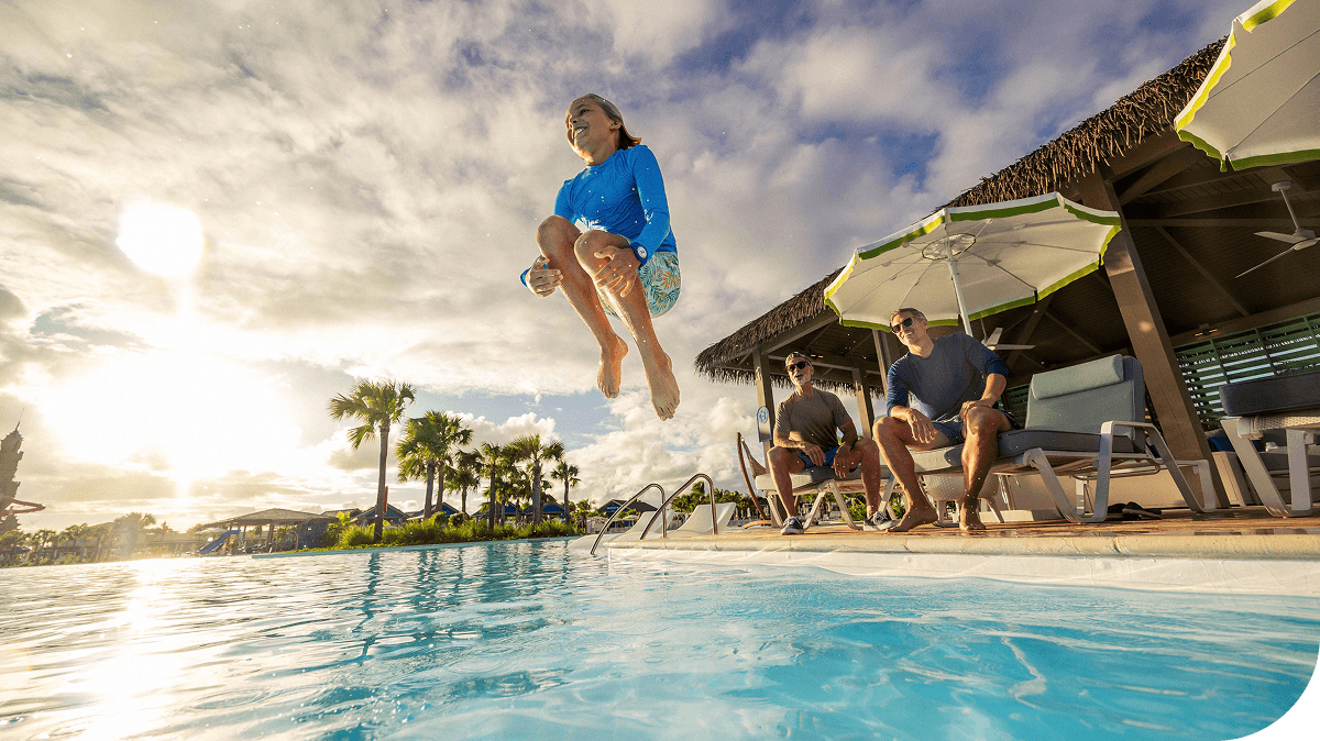 A family enjoys the pool at sunset at Celebration Key, Caribbean.