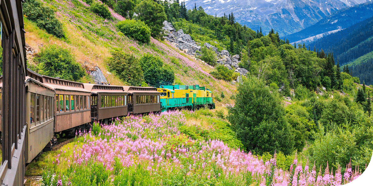 A train travels alongside the hills of Skagway, Alaska.