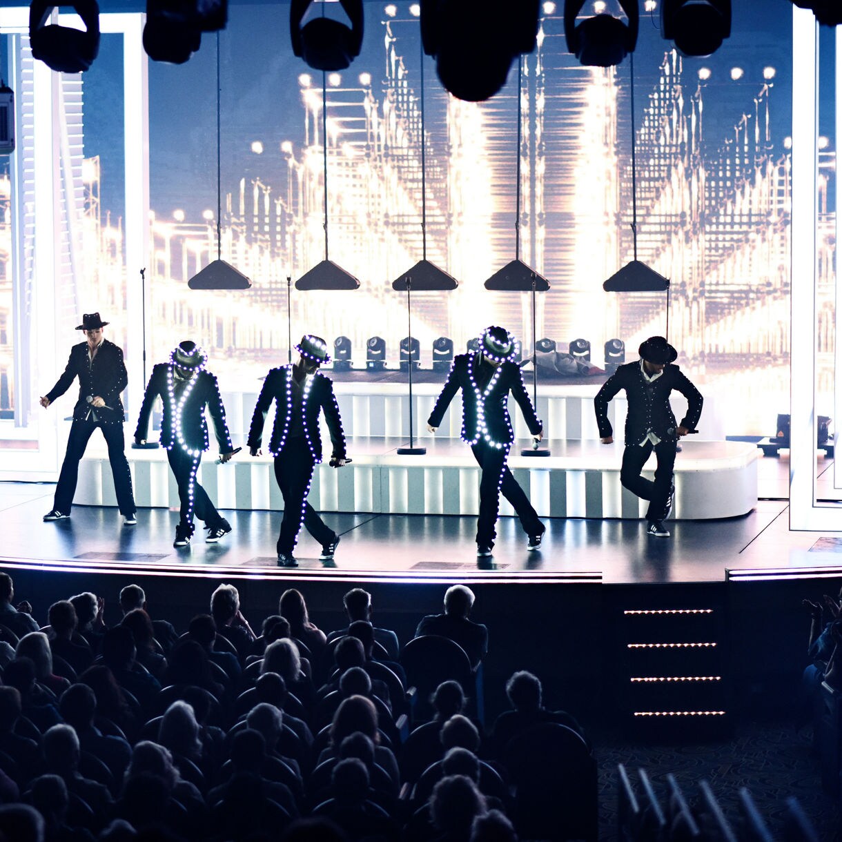 https://assets.princess.com/is/image/princesscruises/production-shows-five-dancers-in-suits-on-stage:1x1-Square?ts=1698256575343