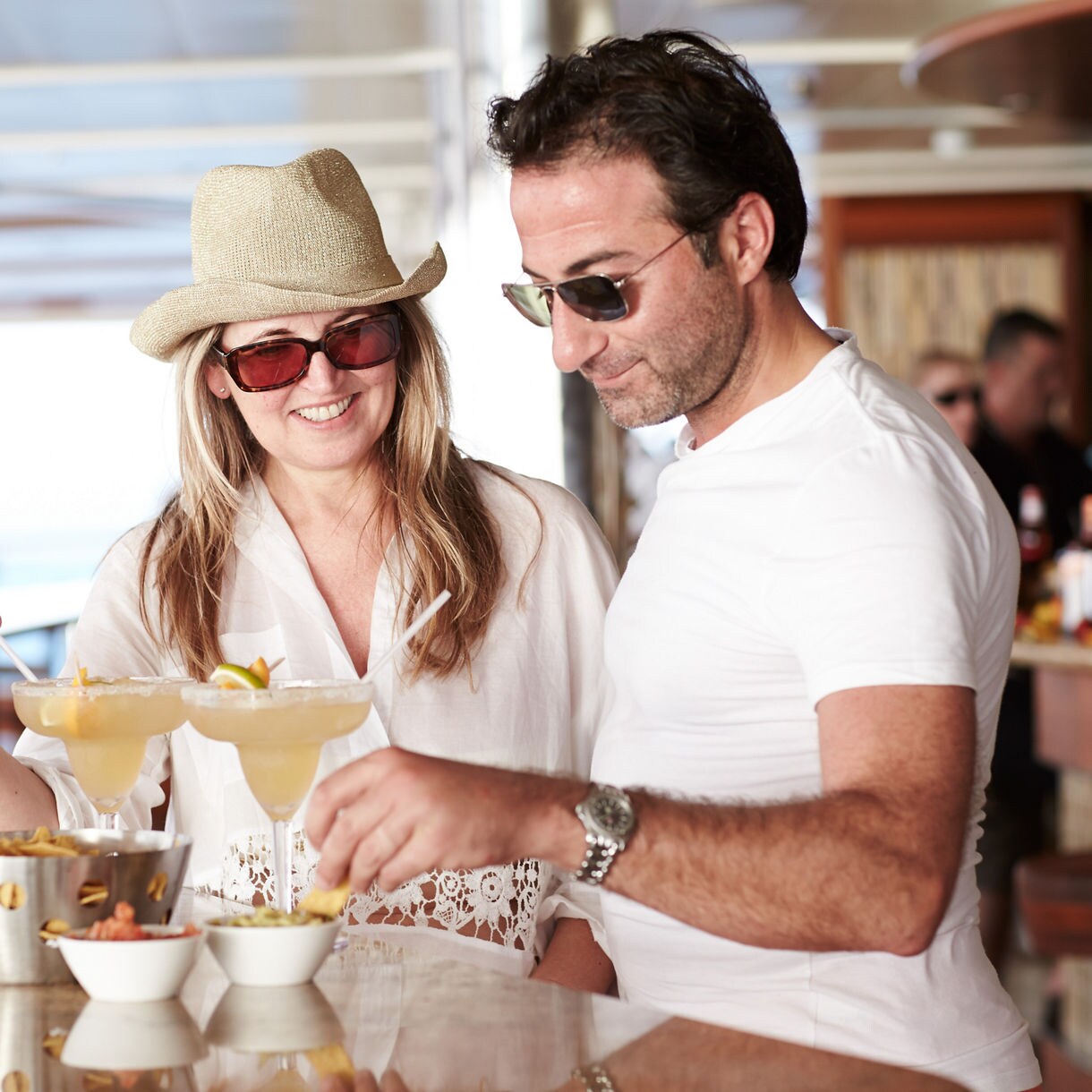 Couple at the bar, drinking margaritas and eating chips with guacamole, on Regal Princess ship/