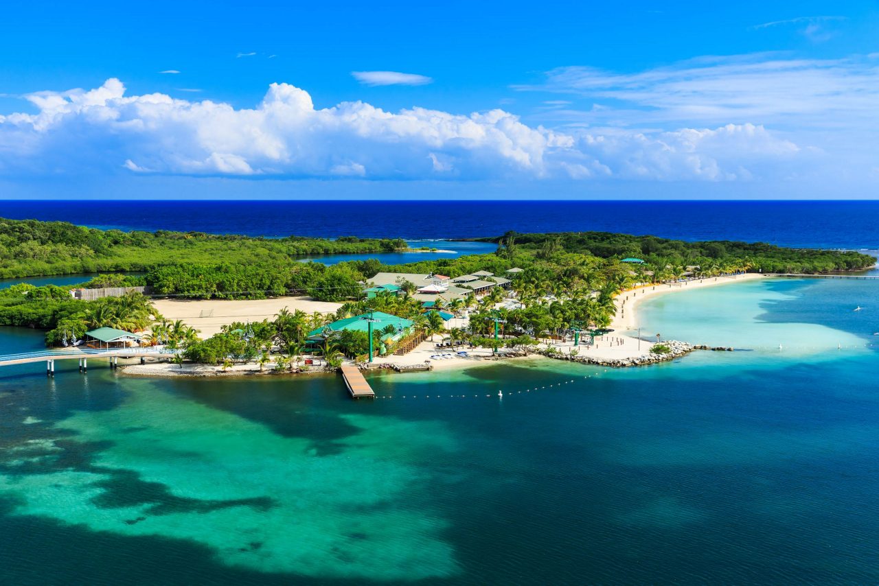Roatán shoreline with anchored boats in water.