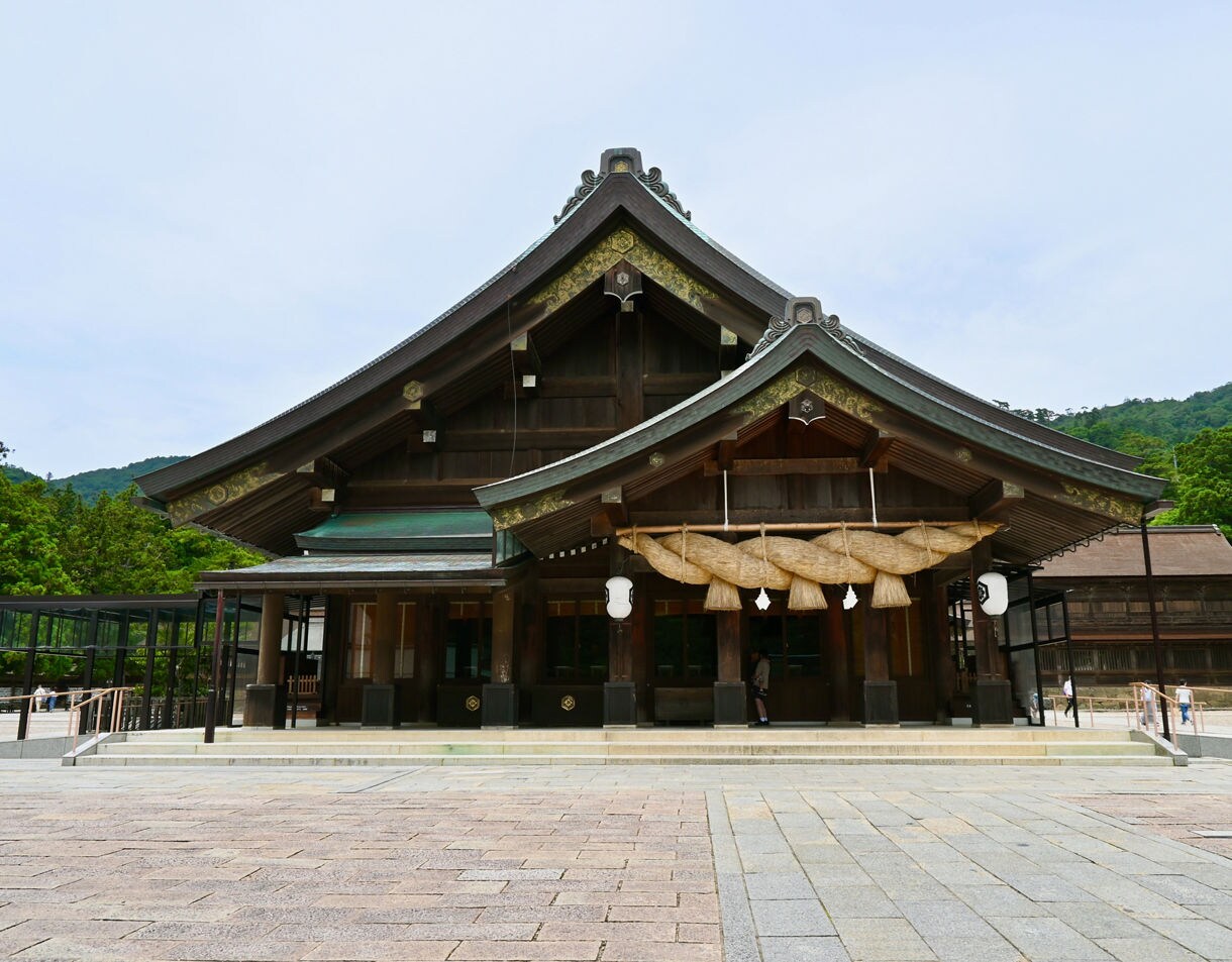 Front view of Izumo Grand Shrine featuring large wooden beams, ornate rooflines and a massive straw rope above the entrance.