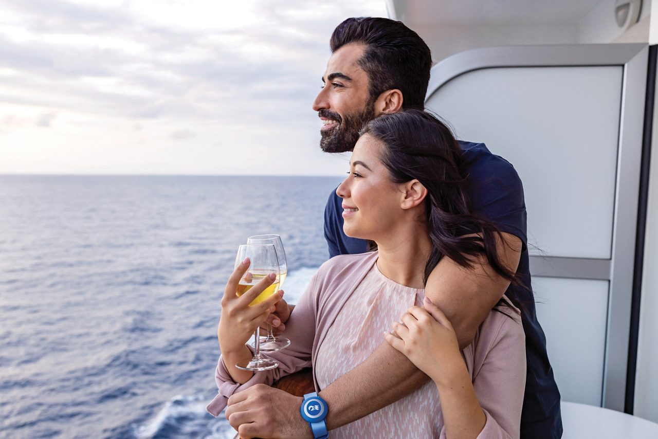 Couplein the balcony embraced and drinking champagne