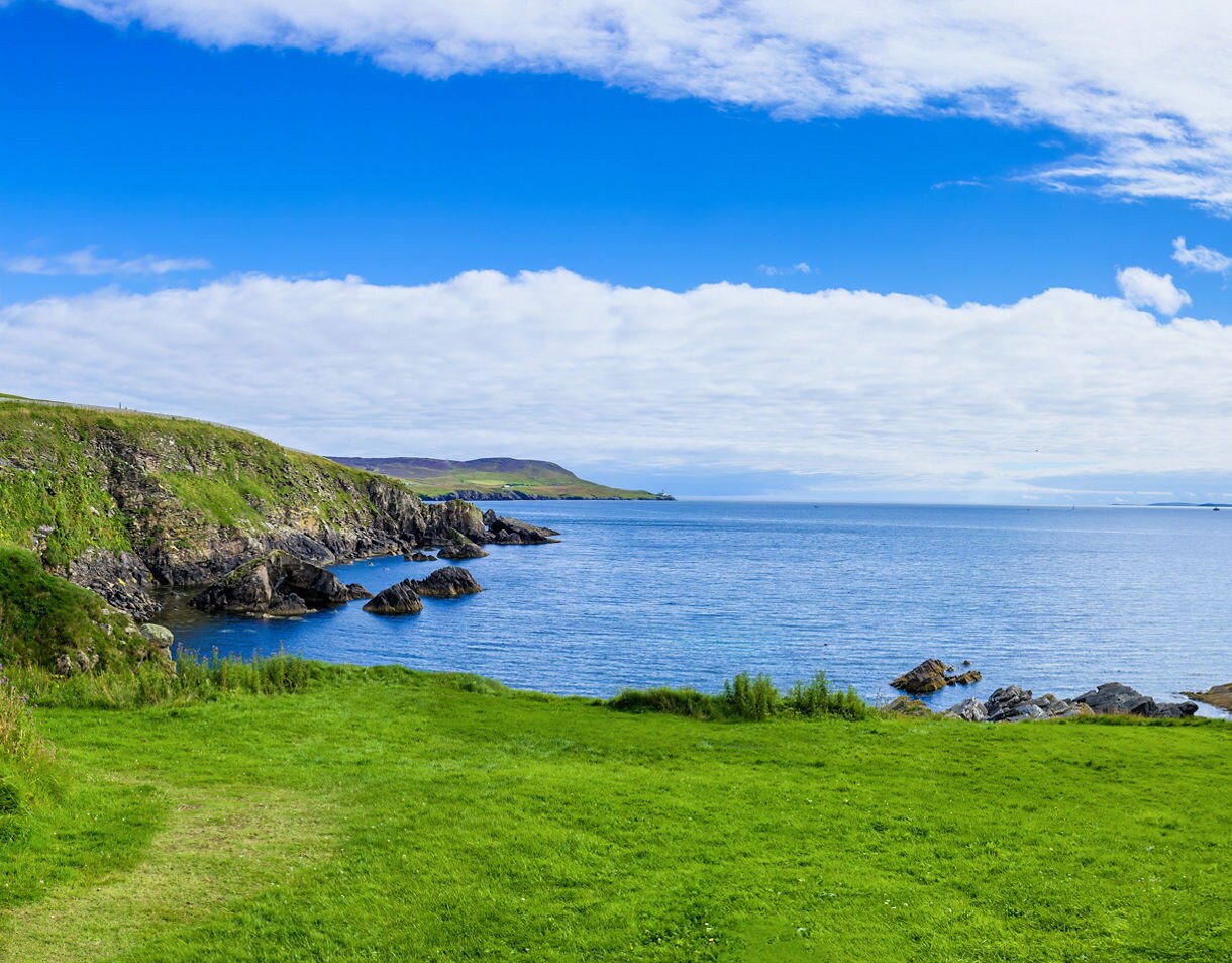 Aerial view of Playa de las Américas in Tenerife with turquoise water, sandy beaches and a bustling resort town backed by mountains.