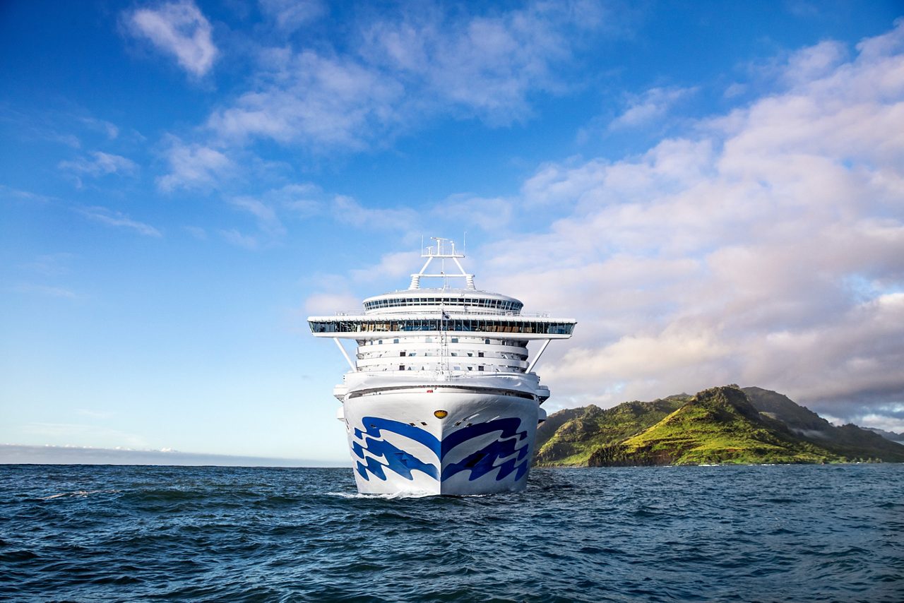 Ship at sea with island and blue sky