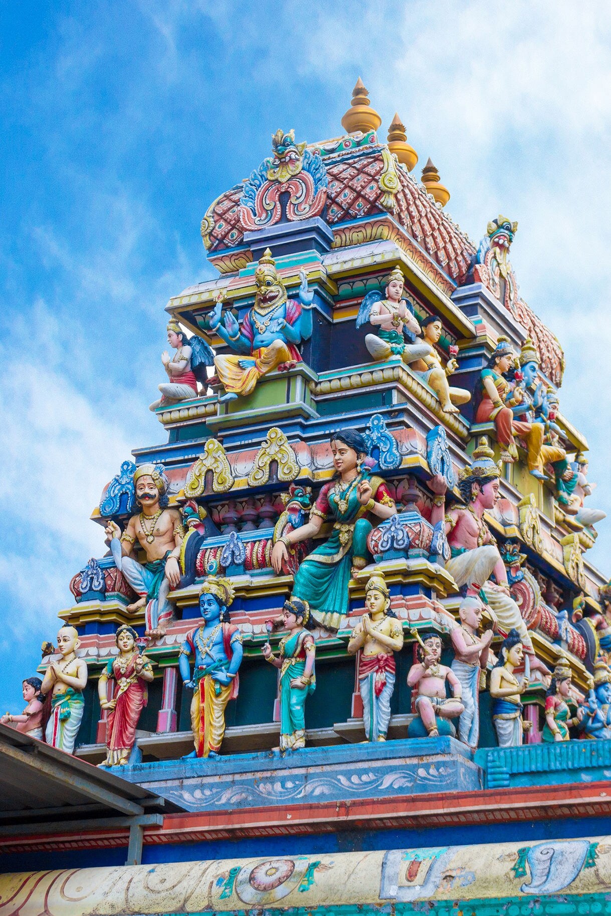 Colorful gopuram tower of Sri Maha Mariamman Temple decorated with detailed Hindu deities and mythological figures.