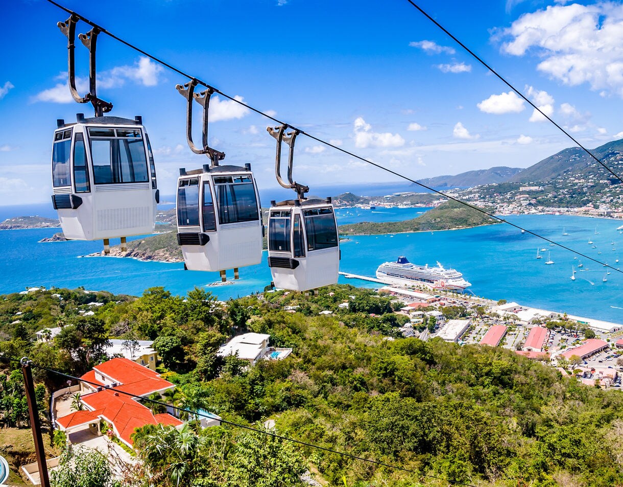 A scenic view of St. Thomas from the Skyride to Paradise Point, featuring a cable car overlooking a harbor