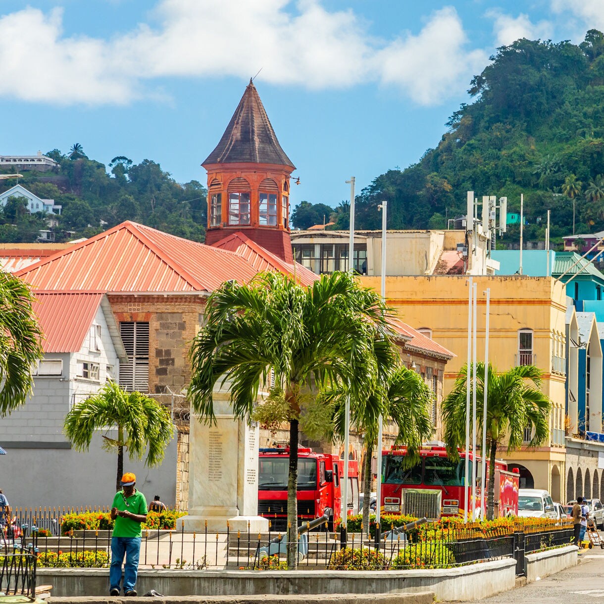 Colorful colonial buildings in Kingstown featuring a distinctive red-roofed clock tower and palm trees.
