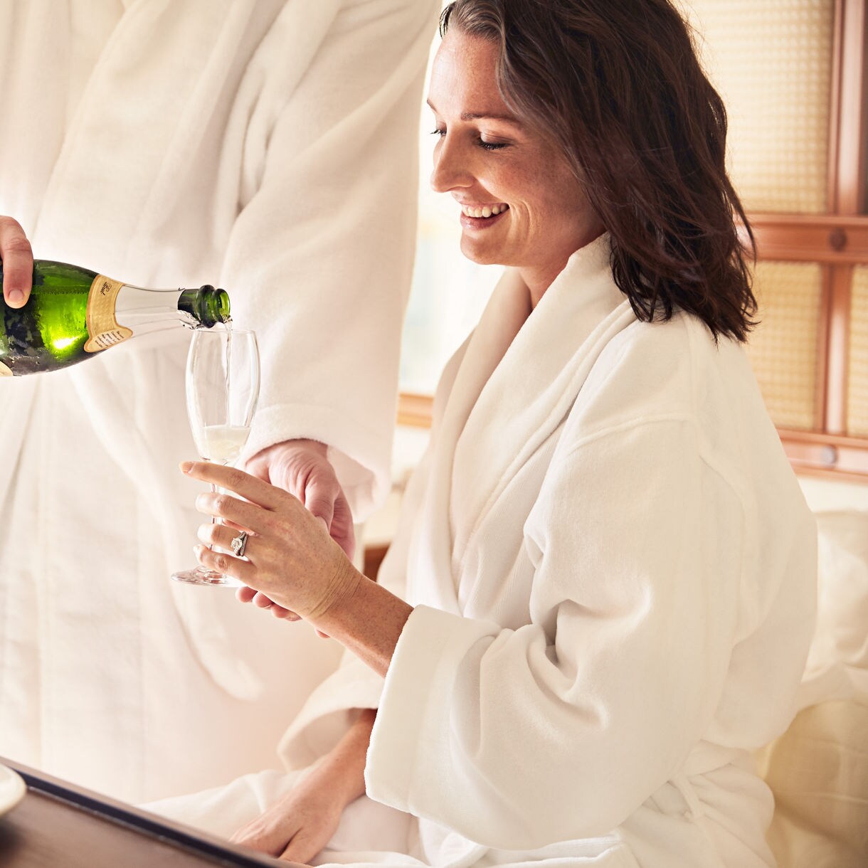 Couple in stateroom with champagne.