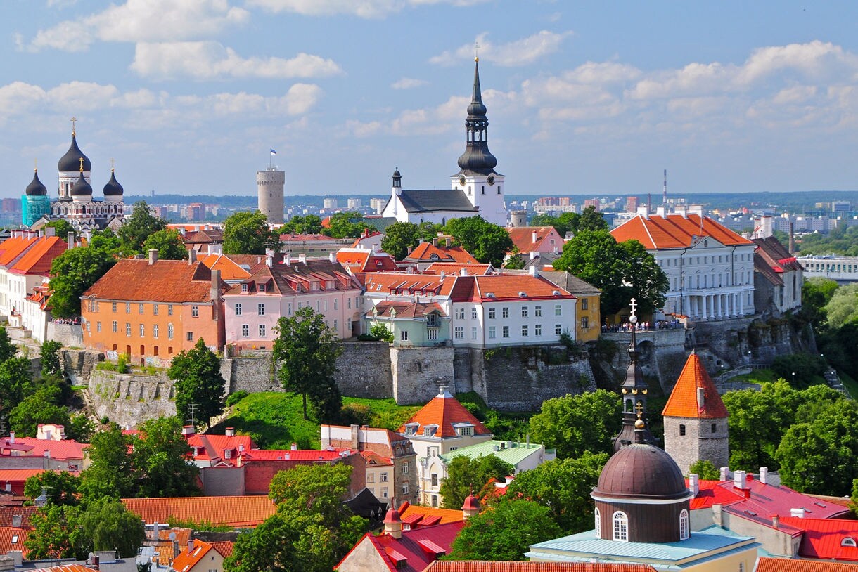 Panoramic view of Tallinn, Estonia, featuring red rooftops, the onion-domed Alexander Nevsky Cathedral, and historic churches, with the modern city in the background.