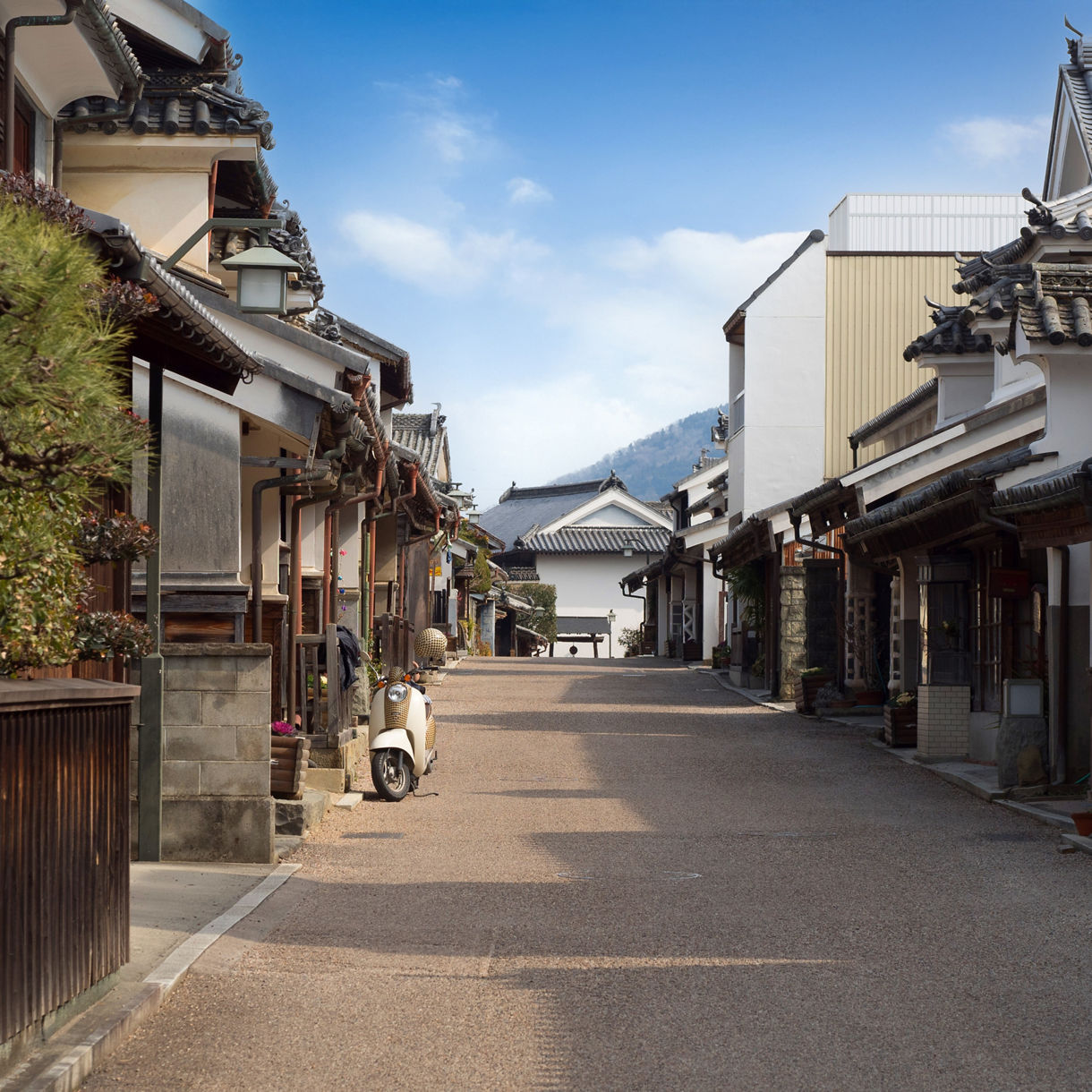 Traditional Japanese street with tiled-roof houses and a parked scooter in Udatsu.