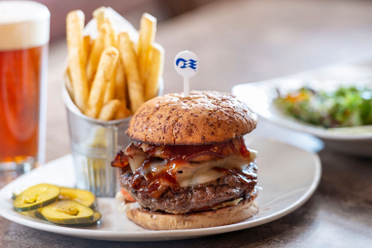 Trackers’ signature burger with bacon onion jam, melted white cheddar, and house‑made BBQ sauce on a toasted potato bun.