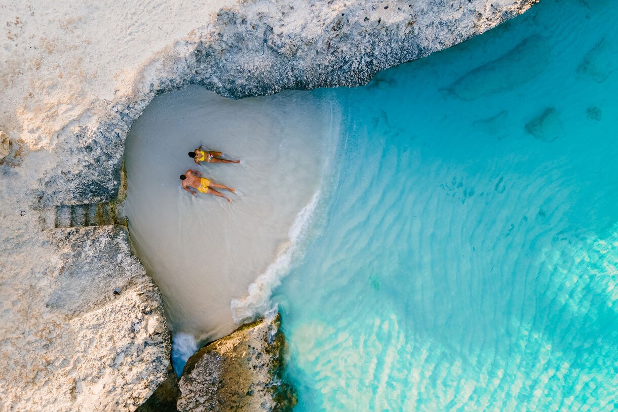 A couple of men and women on the beach of Tres Trap Aruba Caribbean Island.