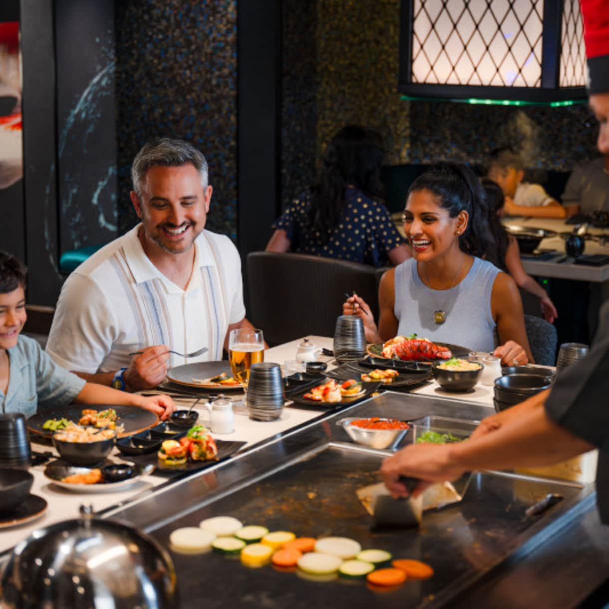 Man eating sushi set with chopsticks on restaurant