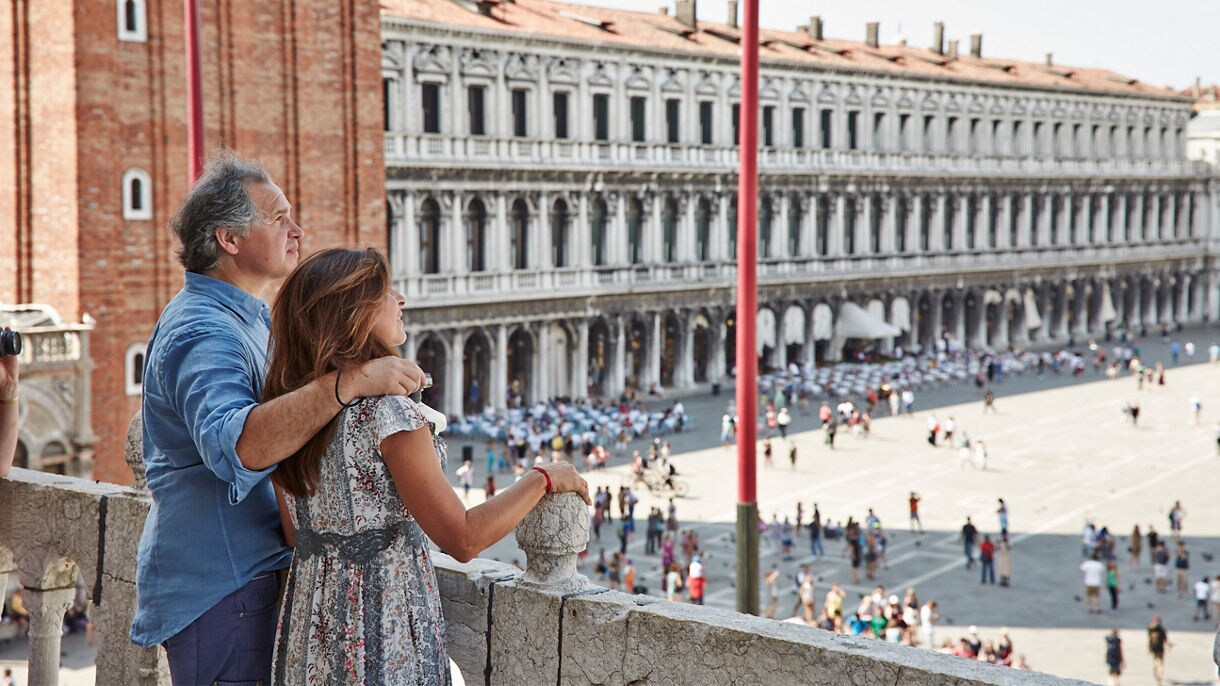Couple embracing, looking towards an open plaza
