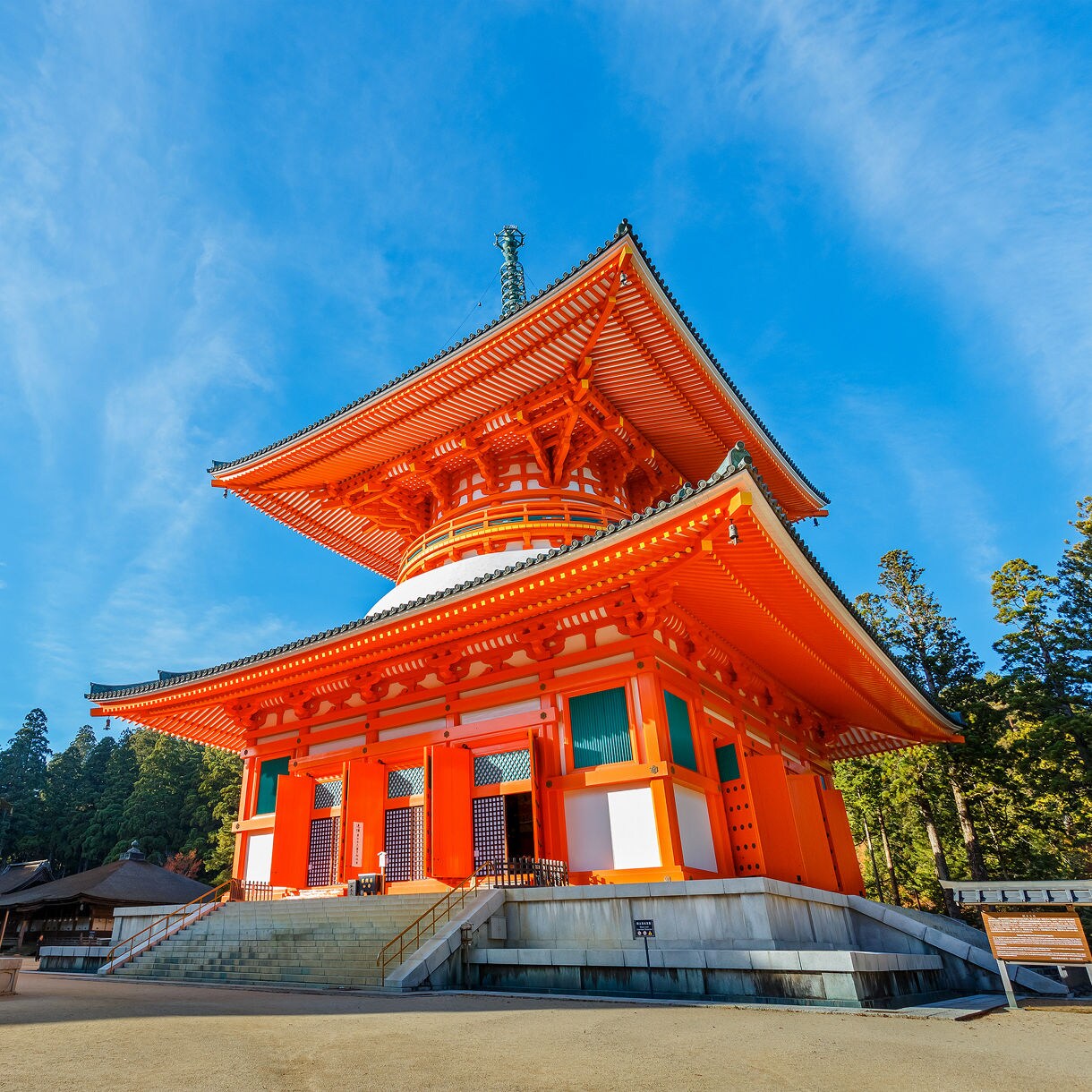 Bright orange pagoda-style temple with sweeping eaves and intricate woodwork at Mt. Koya, Japan.