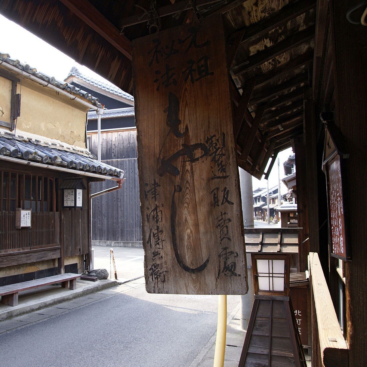 Narrow street lined with historic wooden buildings and a weathered soy sauce shop sign in Yuasa, Japan.