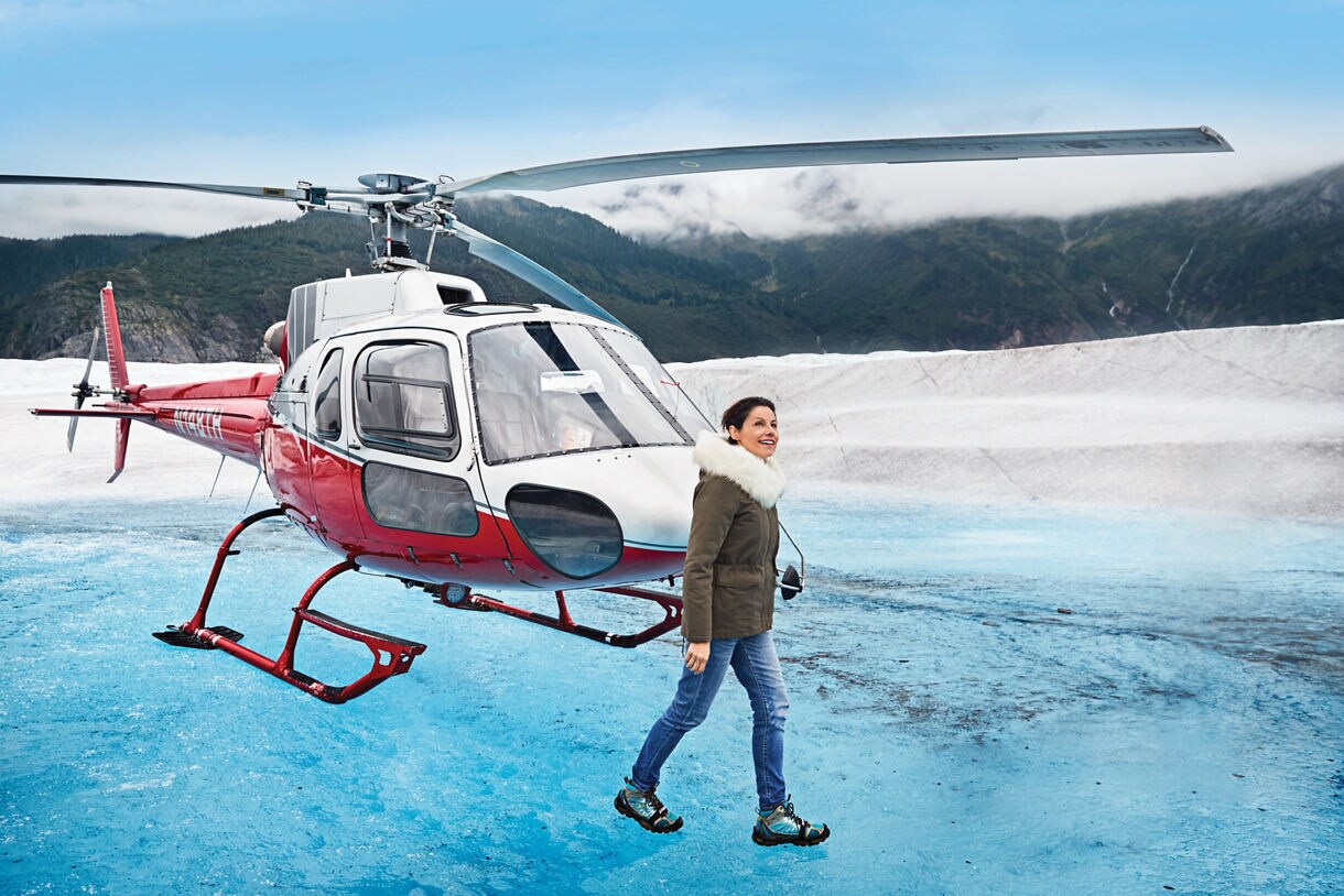 A woman exiting a Helicopter on top of mendenhall glacier
